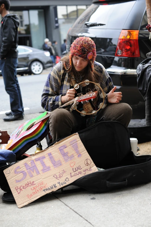 a woman playing the ukulele next to some guitar bags