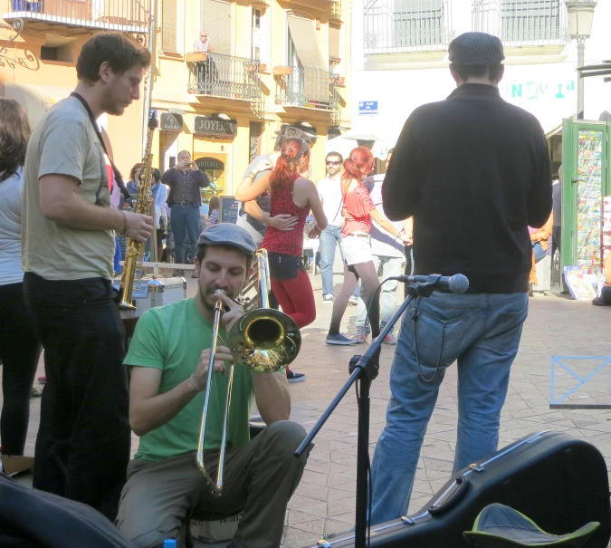 a man in a green shirt plays a trumpet in front of a crowd of people