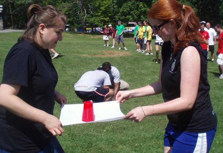 two young ladies holding up a box with a candle