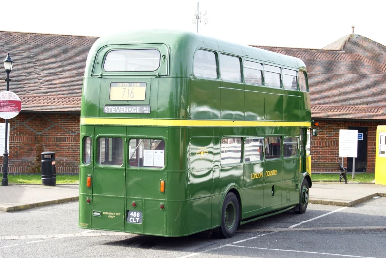 a green double decker bus parked on the street