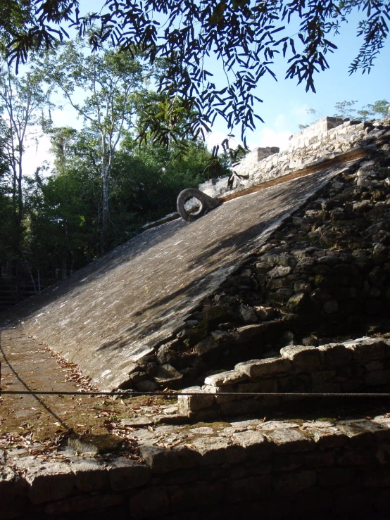 a truck traveling up a ramp to the top of a steep rock structure