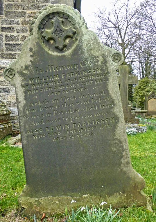 a cemetery with green grass and a cement monument