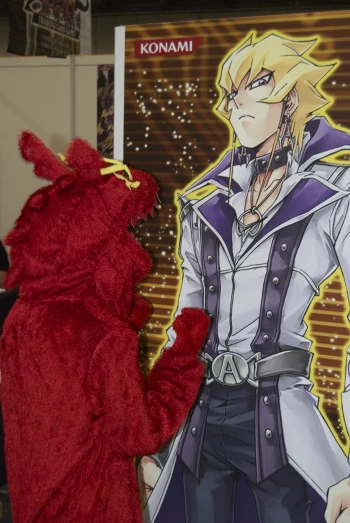 red plush toy stands beside a giant po
