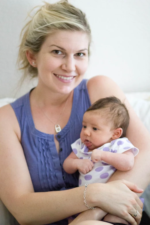 a woman holding her baby on her arms