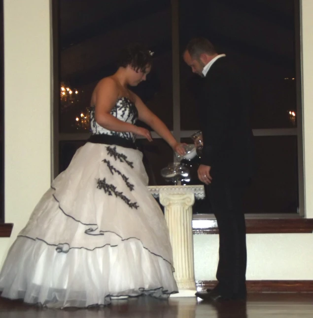 a bride and groom standing next to a table