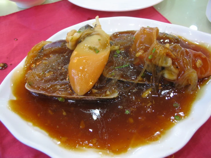 a plate with food on it with sauce and an orange spoon