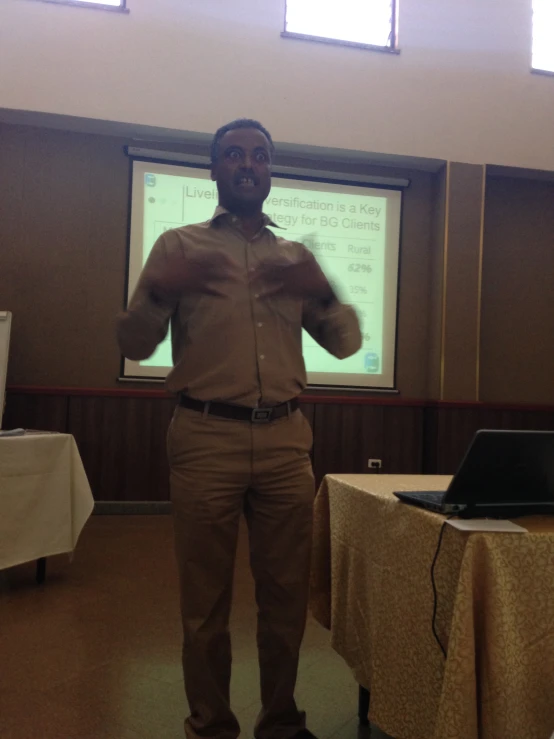 a man standing in front of a projection screen