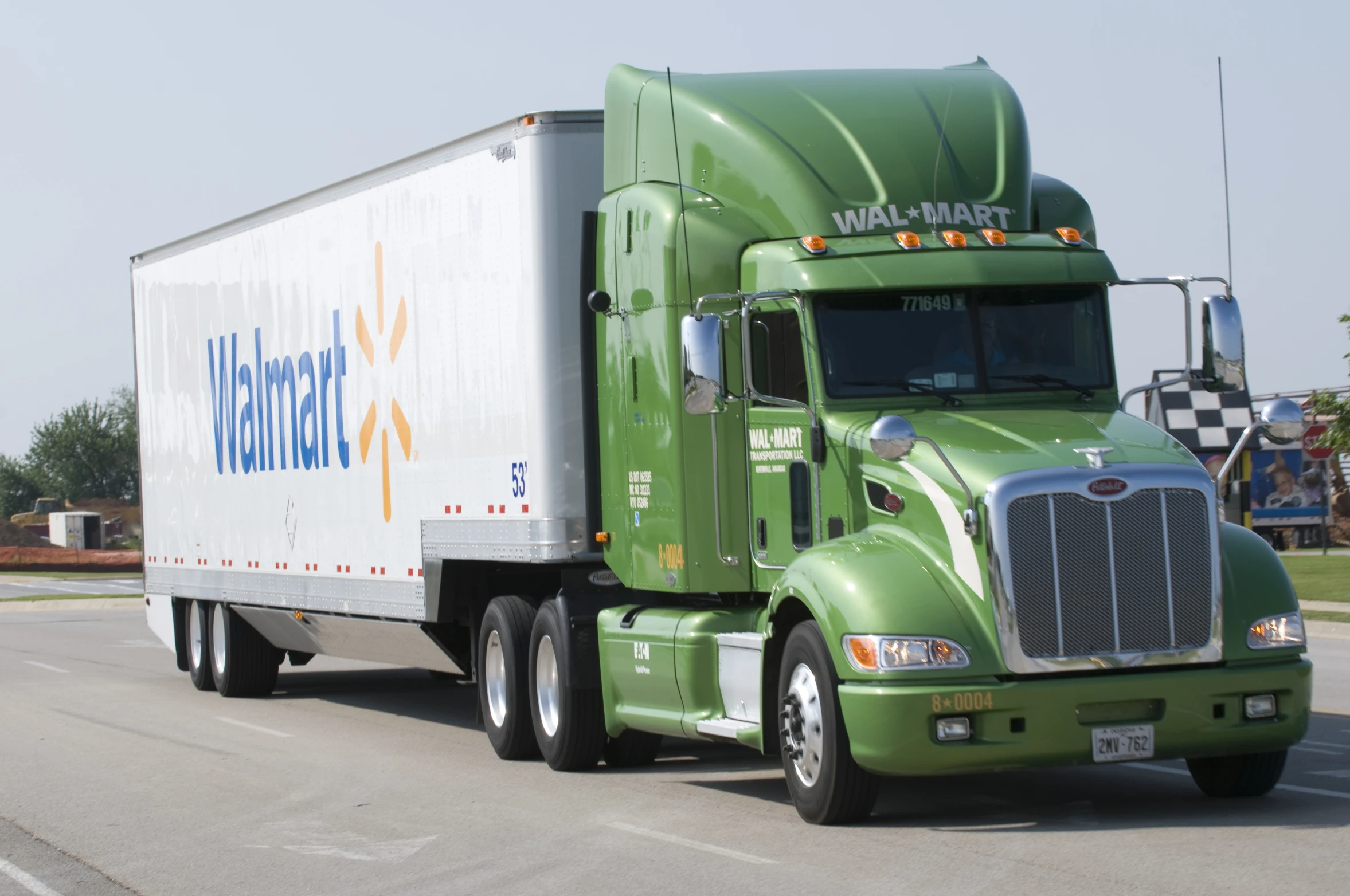 a green semi truck is on the road