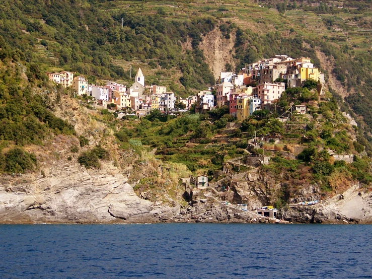 a village sitting on top of a cliff on a lake