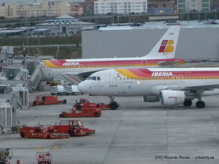 airplanes parked in an airport near other vehicles