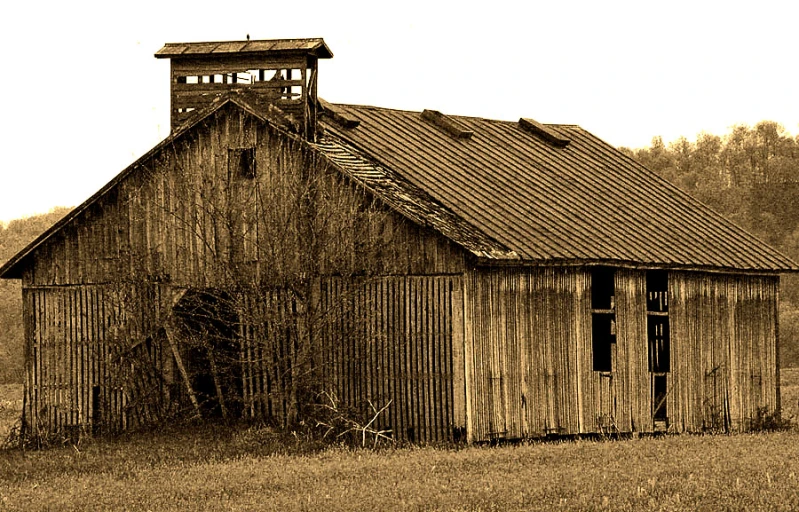 an old house sitting on a field in a rural setting