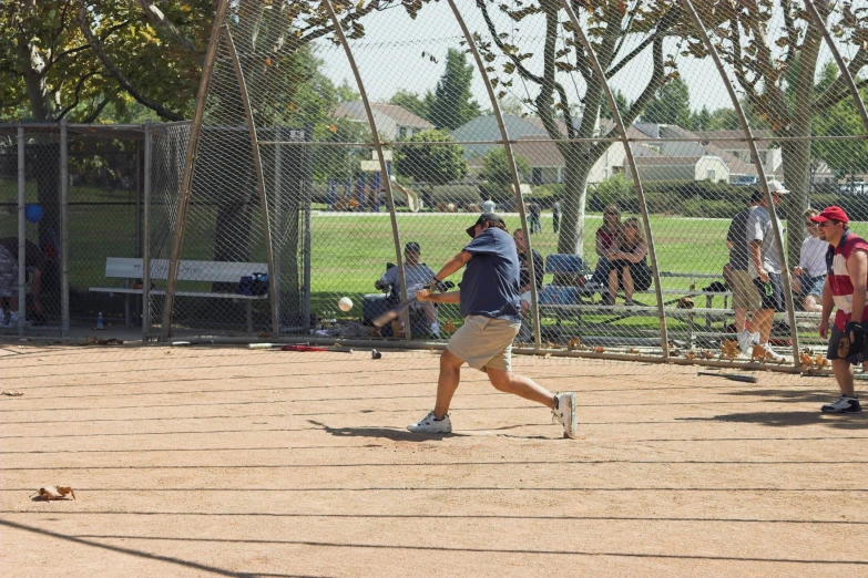 a group of people standing around a baseball field playing