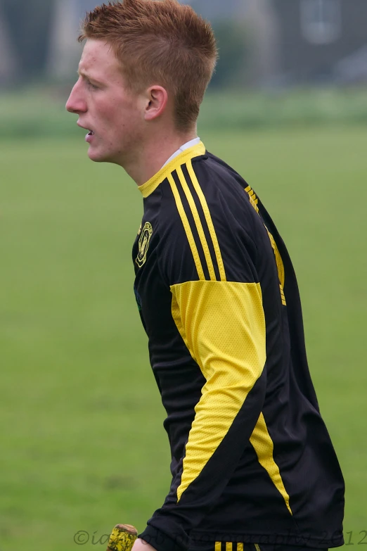 the young man has red hair and is playing soccer