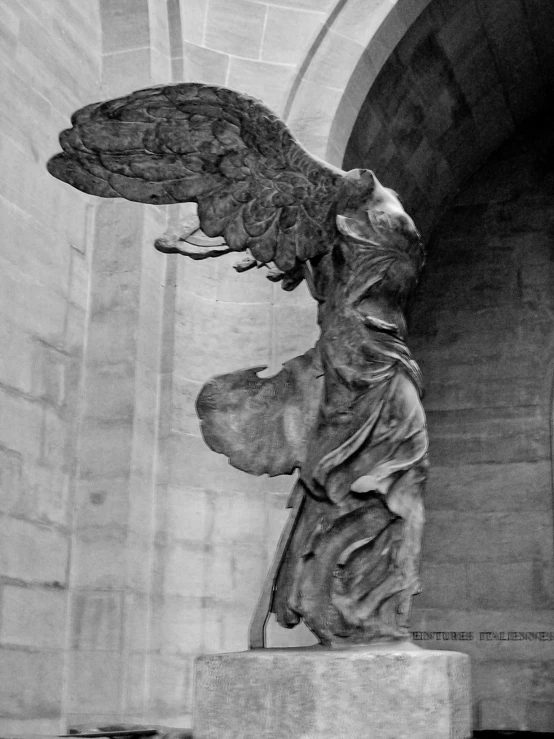 a statue of an angel stands in a very large archway