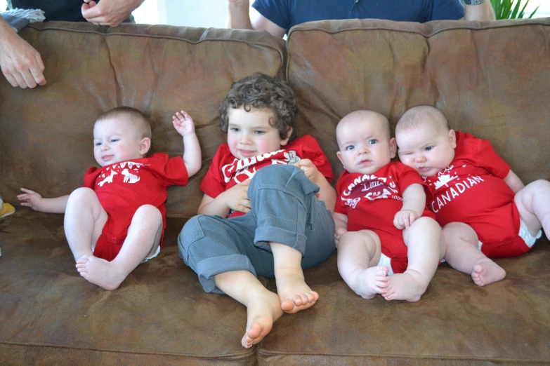 a group of babies sitting on top of a couch