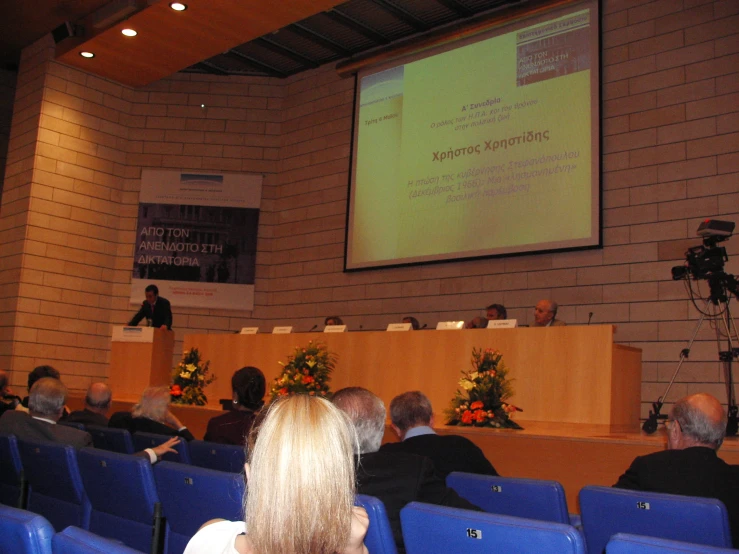 an event at a conference hall with a screen showing data