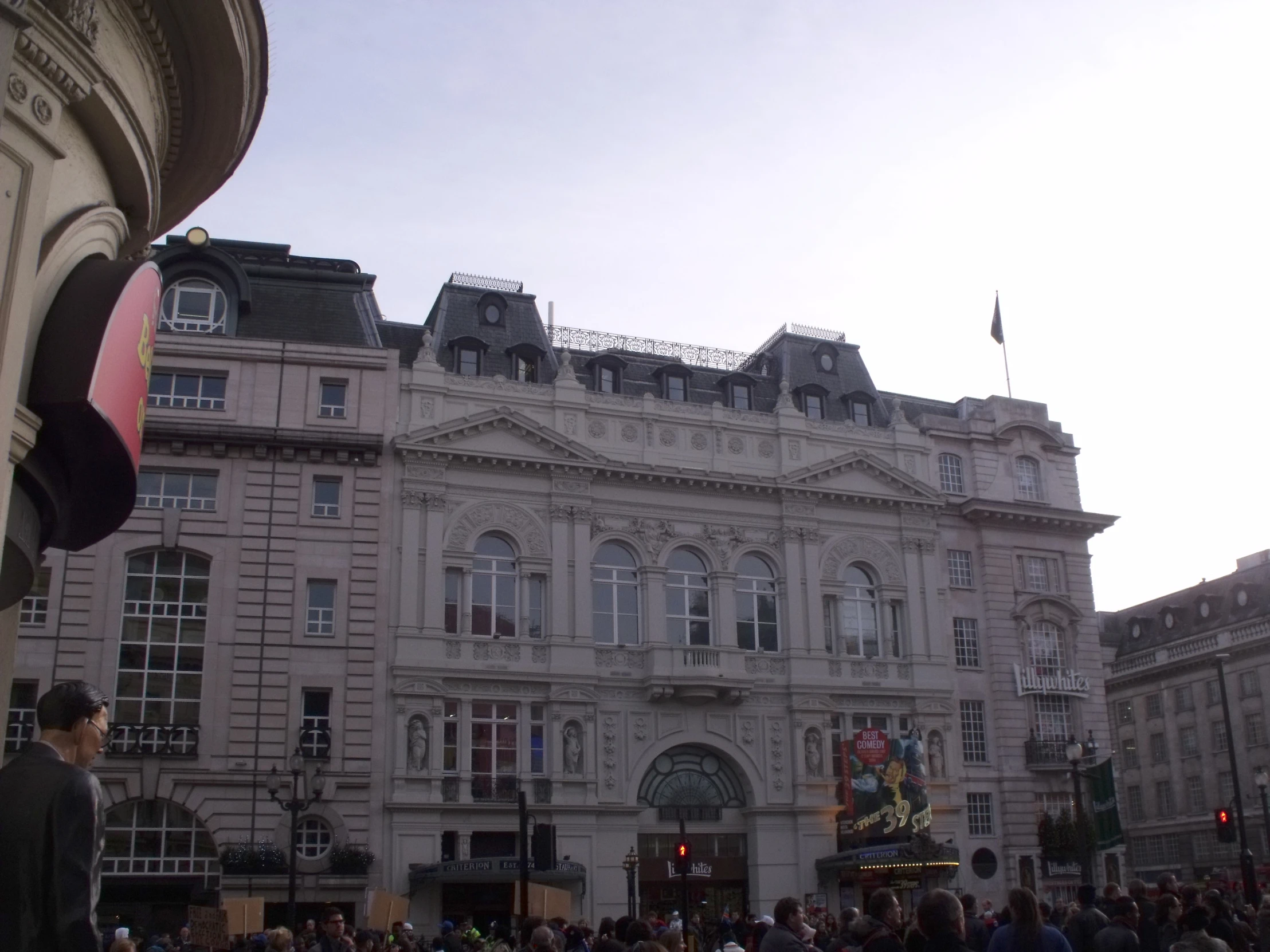 some buildings with people standing around and one person is watching the other