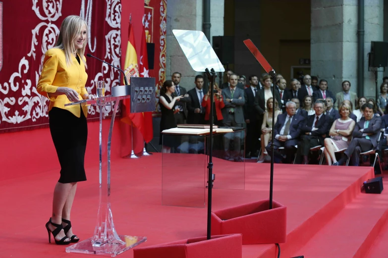 a woman speaking at an event in front of a large crowd