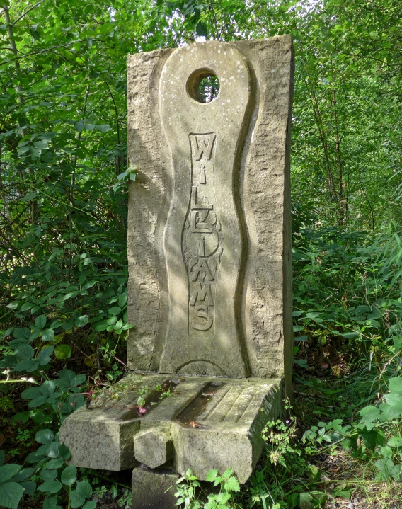 a cement object near trees and bushes