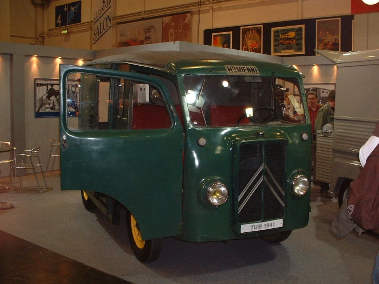 an old green car is on display in a museum