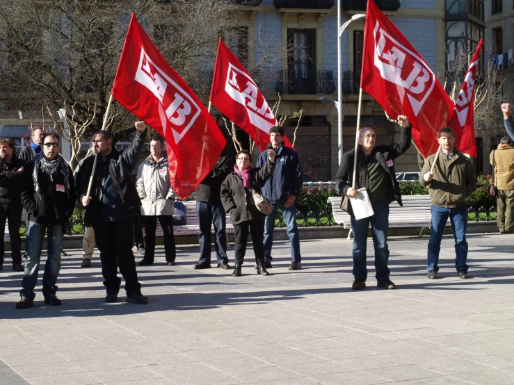 several people with red flags walking on a street