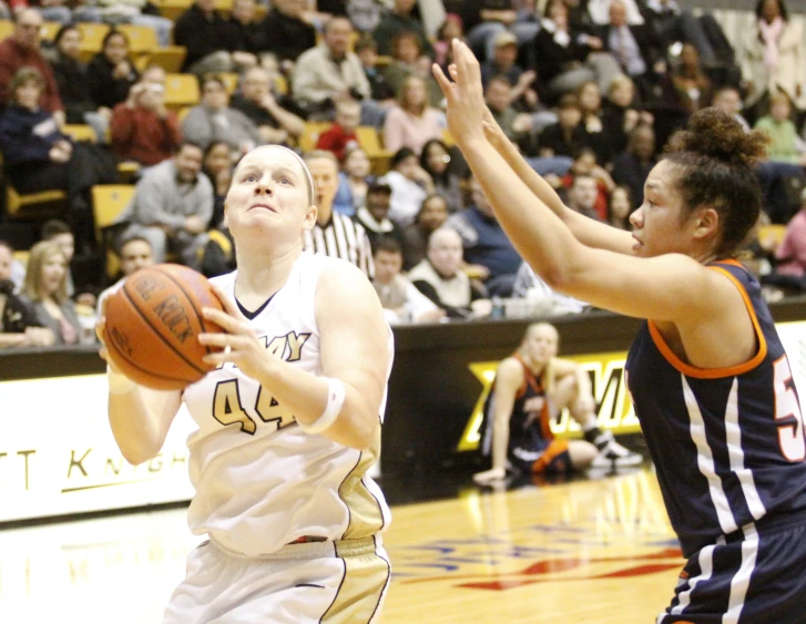two women in white and black uniforms playing basketball