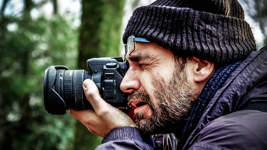 a man in a hat holding a camera