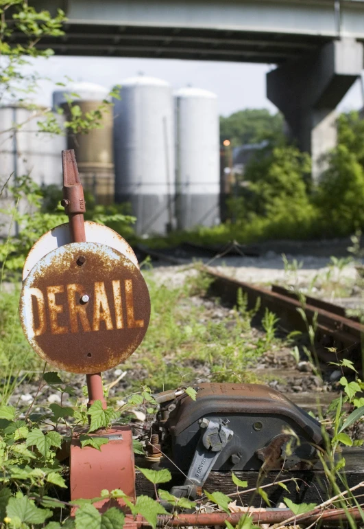 an abandoned train track has rusted into a broken down sign