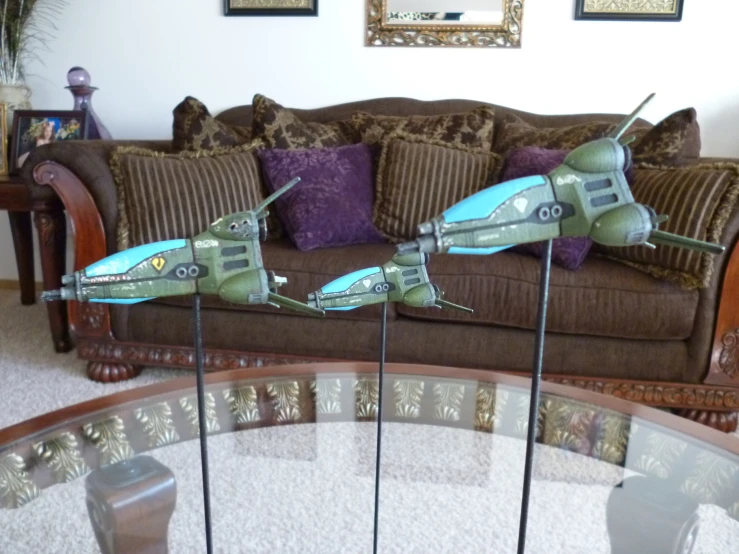 three planes are standing on a glass table