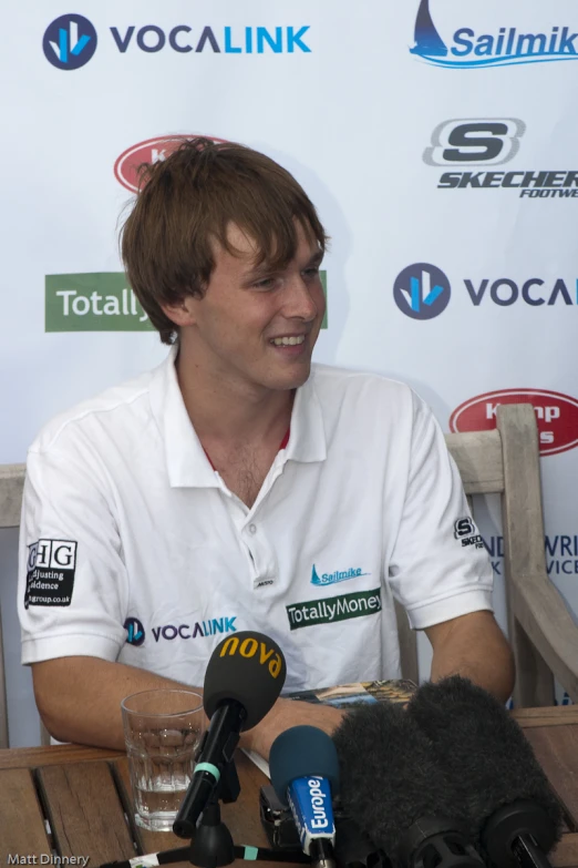 a man is interviewed in front of microphones and recording equipment