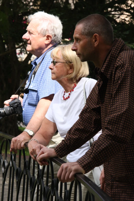 several people are standing by a railing