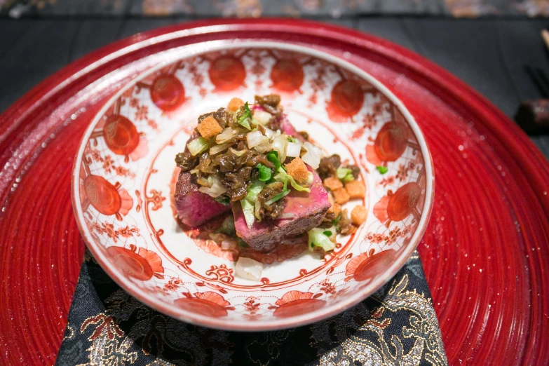 a white plate topped with meat covered in sauce