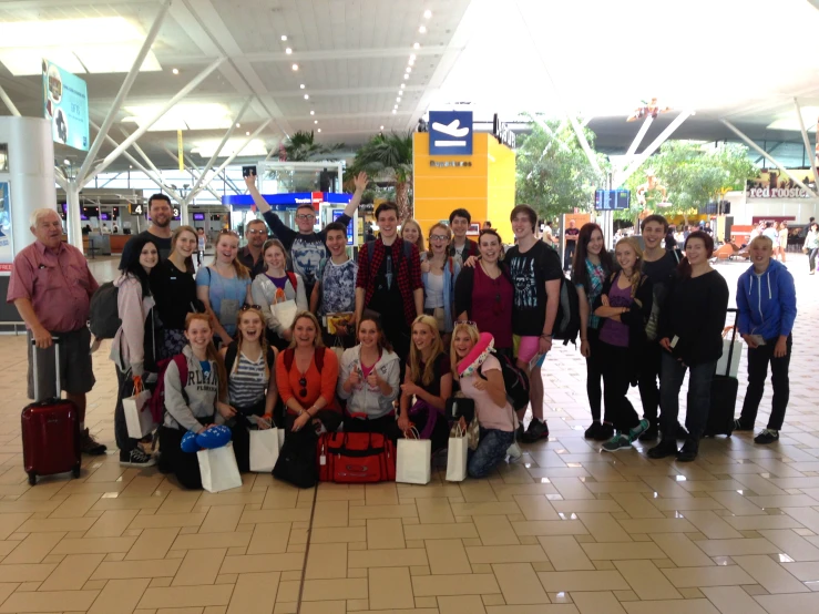 many people are standing together at the airport