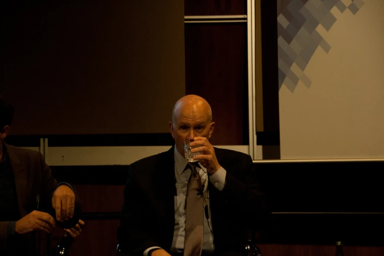 a man is sitting down and drinking a beverage