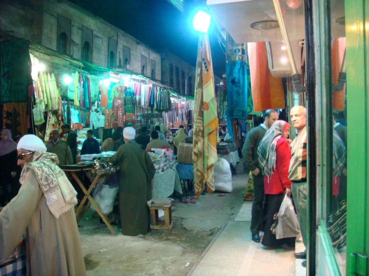 a market with many people shopping and selling clothing