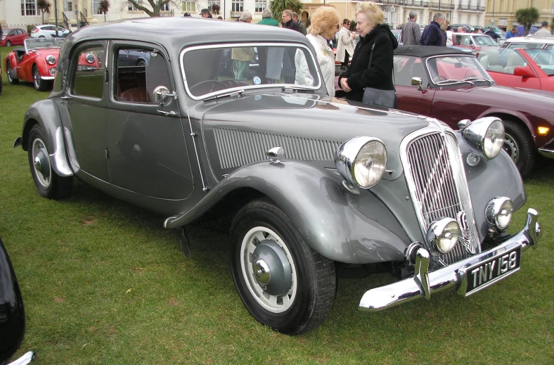 the old grey car is parked on grass