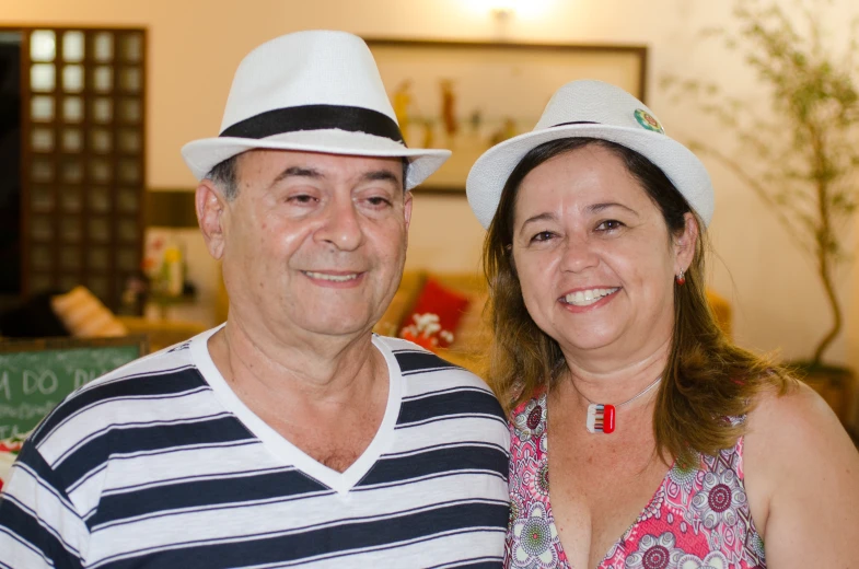 an older man and a young woman who are dressed in hats