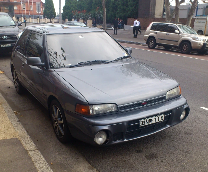 a small car is parked on the side of the street