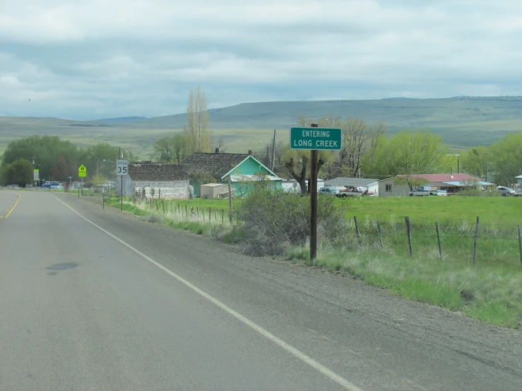 the empty street leads into rural town and a sign for a little church
