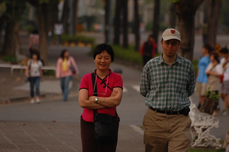 a man and woman standing next to each other on a street