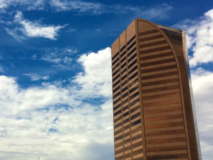 a tall building with curved face sits next to tall buildings on either side