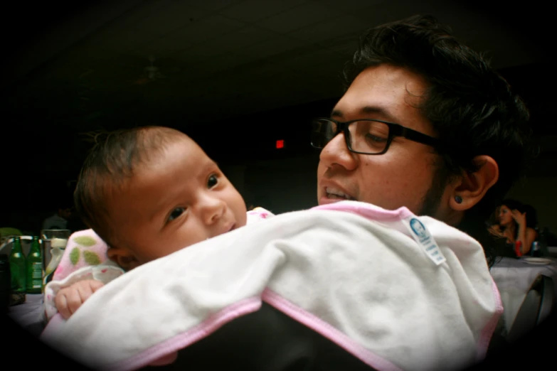 a man holding a baby who is wrapped in a towel