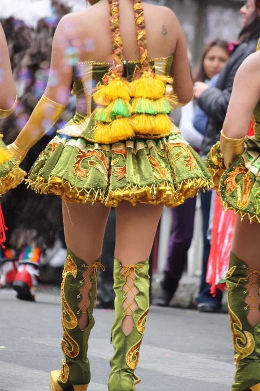 several woman in colorful costumes walking on the street