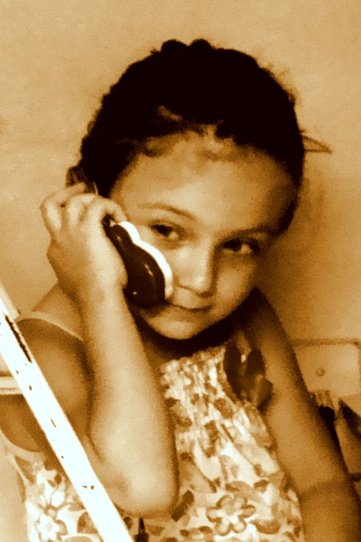 a small girl holding a phone in her right hand