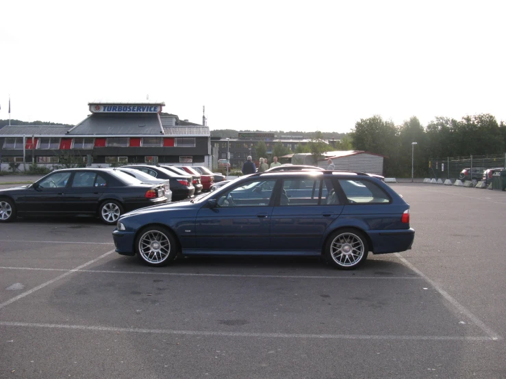 a blue vehicle in a parking lot with other cars