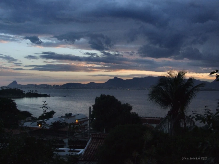 a cloudy sunset with the island in the distance