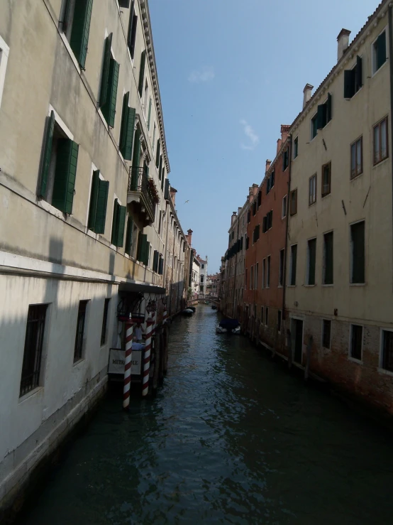 water running between buildings in a city with some windows