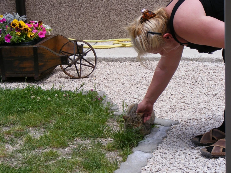 a woman bending over bending down to see the grass