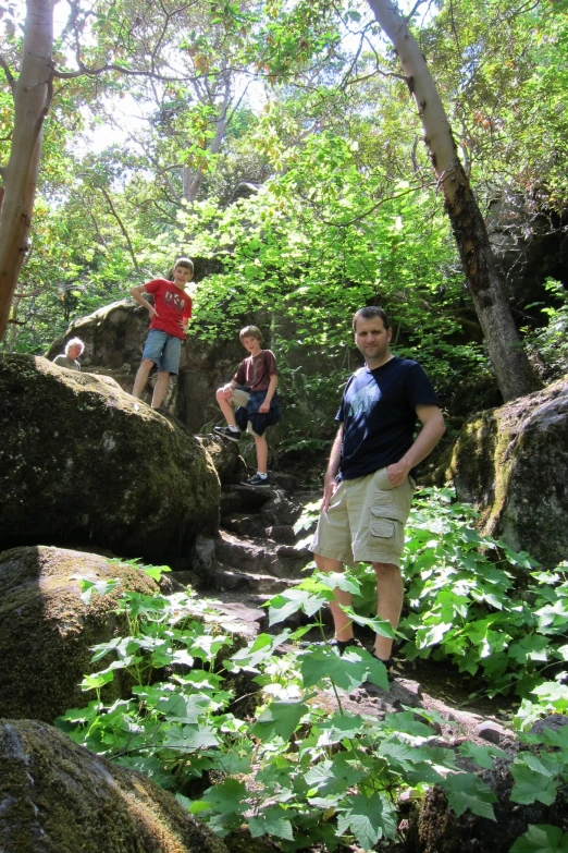 three men hiking down a path in the forest