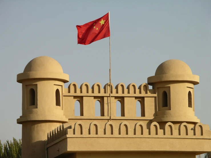 a red flag is standing on top of a building